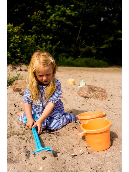 Farverigt sandlegetøjssæt med spande, skovle, forme og vandkander i pastelfarver.